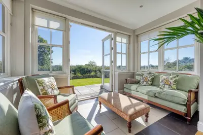 a living room with windows and a couch at Stunning 4 Bedroom Farmhouse in Bishopton