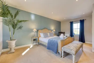 a bedroom with a bed and a potted plant at Stunning 4 Bedroom Farmhouse in Bishopton