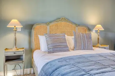 a bedroom with a large bed with two lamps at Stunning 4 Bedroom Farmhouse in Bishopton
