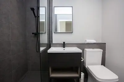 a bathroom with a sink and a toilet and a mirror at Stylish and Modern 2 Bed House in Glasgow