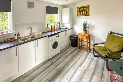 a kitchen with a sink and a washing machine at Quite Charming house near Glasgow in Clydebank