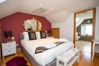 a bedroom with a large bed with a mirror at The Banking Hall in Polmont