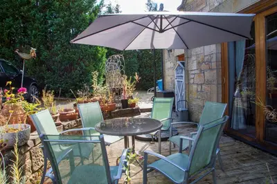 a table and chairs with an umbrella on a patio at The Banking Hall in Polmont