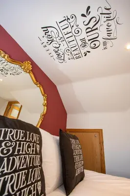 a bedroom with a bed with the words true love and an affectionateuteute at The Banking Hall in Polmont