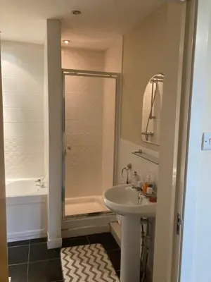 a bathroom with a shower and a sink and a tub at Duplex Apartment in Glasgow