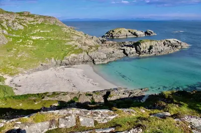an aerial view of a beach with rocks in the ocean at Little cottage-Village of Bunessan-Sleeps4 in Bunessan