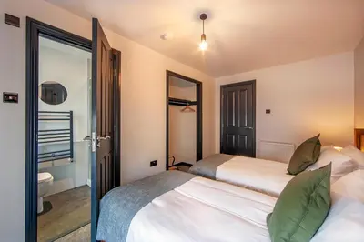 a bedroom with two beds and a bathroom at Exceptional 2BD Apt - next to ferry & train station in Oban