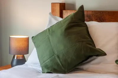 a green pillow sitting on top of a bed at Exceptional 2BD Apt - next to ferry & train station in Oban