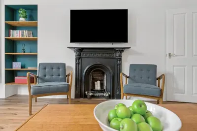 a living room with a fireplace and a bowl of apples at Woodford Street in Mansewood