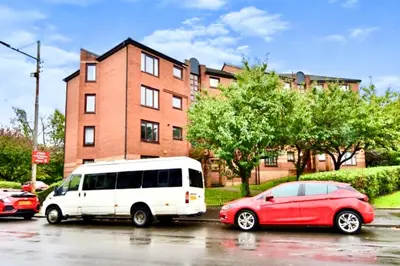 a white van and a red car parked in a parking lot at Cityview Retreat - 2-Bed Apartment - Free Parking in Glasgow