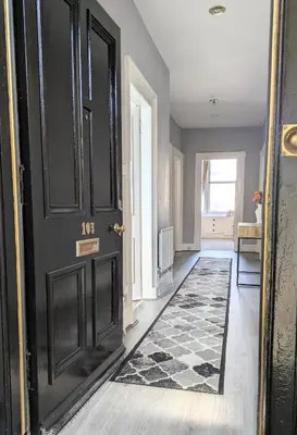 a hallway with a black door and a rug at Campbeltown Retreat in Campbeltown