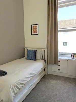 a small bedroom with a bed with a window at Campbeltown Retreat in Campbeltown
