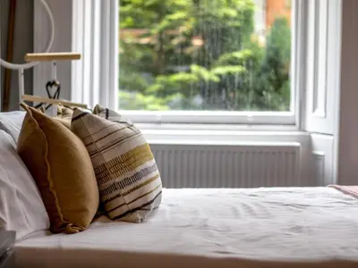 a bed with pillows sitting in front of a window at Studio Dream with Loft West End - Pass the Keys in Glasgow