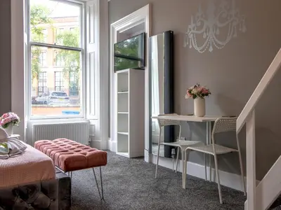 a bedroom with a bed and a table and a window at Studio Dream with Loft West End - Pass the Keys in Glasgow