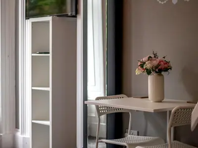 a table and chairs with a vase of flowers on it at Studio Dream with Loft West End - Pass the Keys in Glasgow