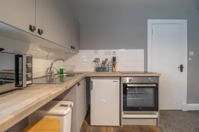 a kitchen with a counter and a sink and a stove at Cosy Palm Studio West End - Pass the Keys in Glasgow
