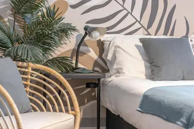 a bedroom with a bed and a table with a lamp at Cosy Palm Studio West End - Pass the Keys in Glasgow