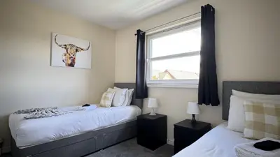 a bedroom with two beds and a window at Kingfisher Apartment in Dunfermline
