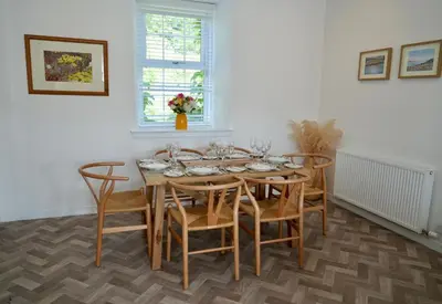 a dining room with a wooden table and chairs at Country Cottage on Private Estate in Minishant