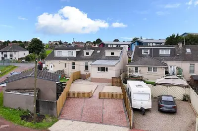 an aerial view of a house with a van parked in a driveway at Diamond House - 4 bedroom luxury home in Airdrie