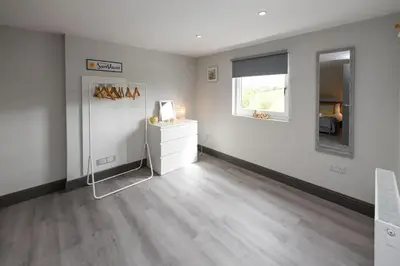 a white room with a dresser and a mirror at Diamond House - 4 bedroom luxury home in Airdrie