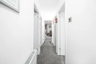 a corridor of a hallway with white walls at Super Prime Abbey Free Parking by TBA in Dunfermline