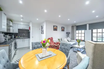 a kitchen and a living room with a table and chairs at Super Prime Abbey Free Parking by TBA in Dunfermline