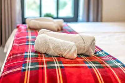 a bed with two towels sitting on top of it at Super Prime Abbey Free Parking by TBA in Dunfermline