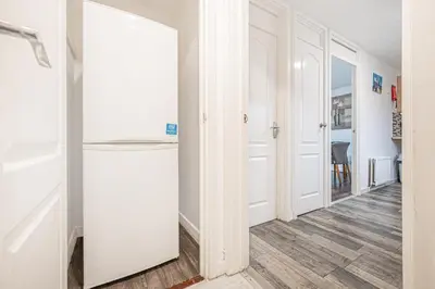 a hallway with white walls and a white door at Pure Home Rosyth Dockyard by TBA in Rosyth