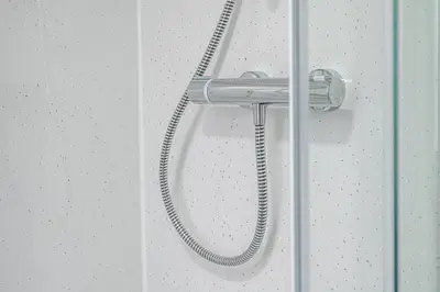 a shower with a hose hanging on a wall at Pure Home Rosyth Dockyard by TBA in Rosyth