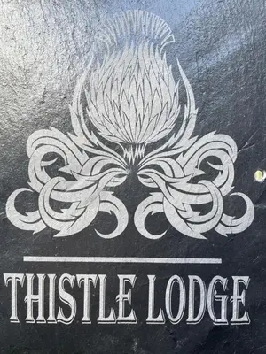 a chalkboard with the title whistle lodge on it at Thistle Lodge in Dollar