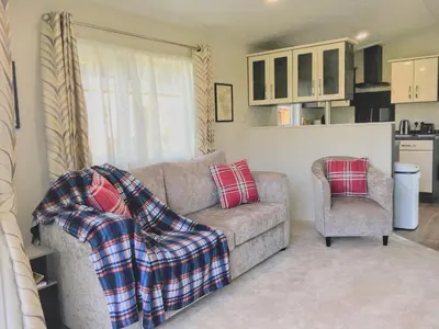 a living room with a couch and a chair at Thistle Lodge in Dollar