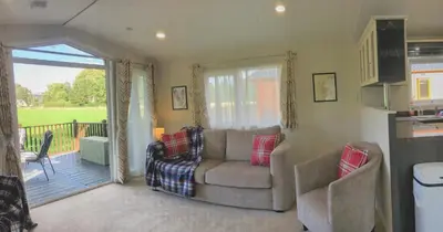 a living room with a couch and a balcony at Thistle Lodge in Dollar