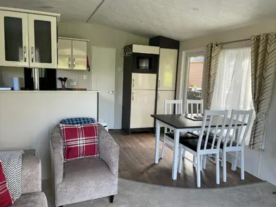 a kitchen and dining room with a table and chairs at Thistle Lodge in Dollar