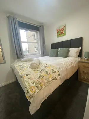 a bedroom with a large bed with a window at Prime City Centre - Ground Floor Parking by TBA in Dunfermline
