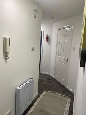 a hallway with a white door and a radiator at Prime City Centre - Ground Floor Parking by TBA in Dunfermline
