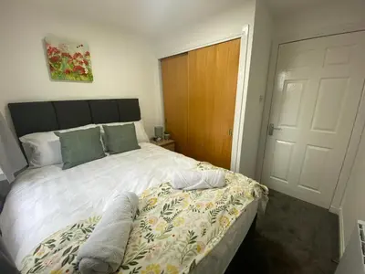 a bedroom with a large white bed and a door at Prime City Centre - Ground Floor Parking by TBA in Dunfermline