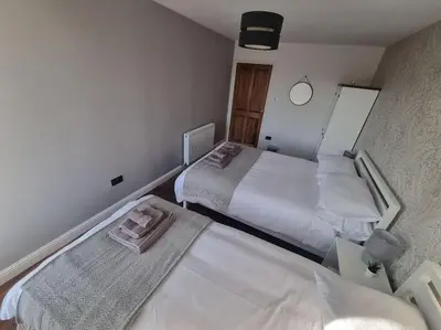 a small bedroom with two beds and a mirror at Mafeking Place Apartment in Campbeltown