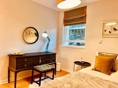 a bedroom with a bed and a dresser and a mirror at Castle View Retreat in Edinburgh