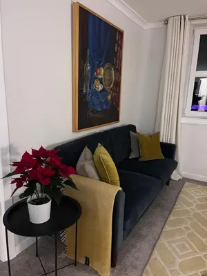 a living room with a blue couch and a table at Castle View Retreat in Edinburgh