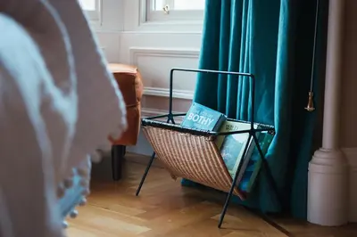 a book sitting on a chair next to a curtain at Beautiful central Edinburgh Apartment in Edinburgh