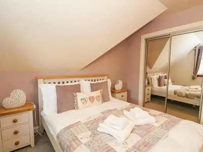 a bedroom with a bed and a large mirror at Taighean Anndra in Killin