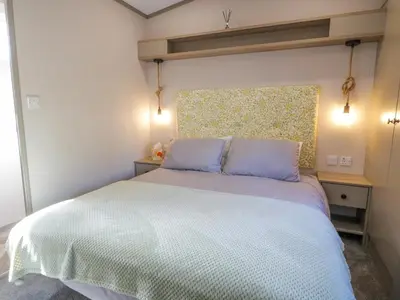 a bedroom with a large white bed with two pillows at 11A Mansion View in Helensburgh