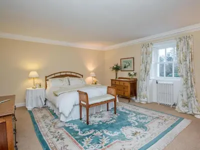 a bedroom with a bed and a table and a window at Country Home on Private Estate in Minishant
