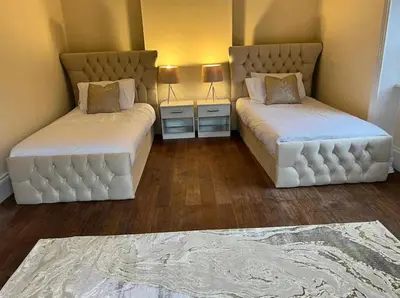 two beds sitting in a room with two lamps at 3 Bed - Sleeps 7 - Free Parking - Central Location in Glasgow