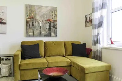 a living room with a couch and a painting on the wall at Blackness Apartment in Linlithgow