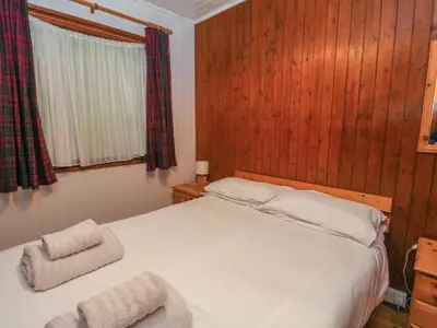 a bedroom with a bed with two towels on it at Lodge 5 - 