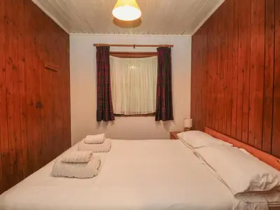 a bedroom with a bed with two towels on it at Lodge 5 - 