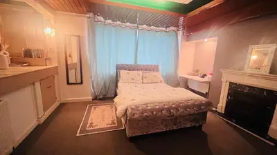 a small bedroom with a bed and a fireplace at Room in a Home in Edinburgh