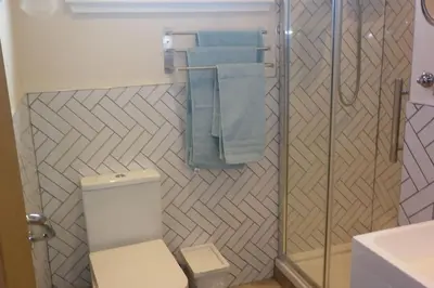 a bathroom with a shower and a toilet and towels at Highland Snug in Dunoon